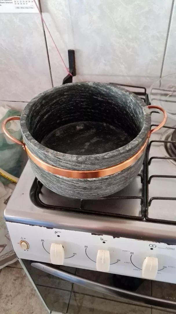 Interior de uma panela de pedra sabão sobre o fogão