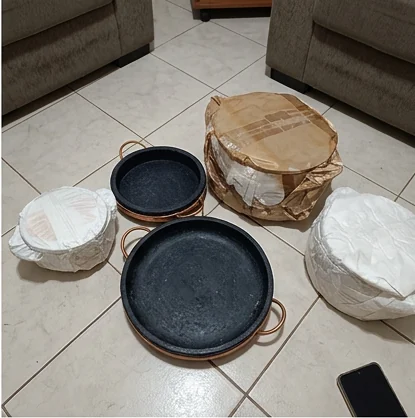 Panelas de pedra sabão junto às embalagens de proteção