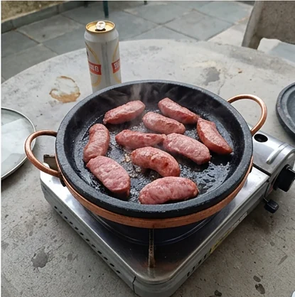 Alimentos sendo preparados em uma panela de pedra sabão